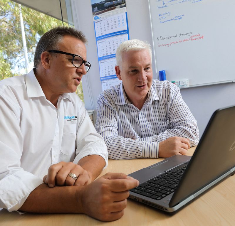 Businessmen discussing while checking the laptop