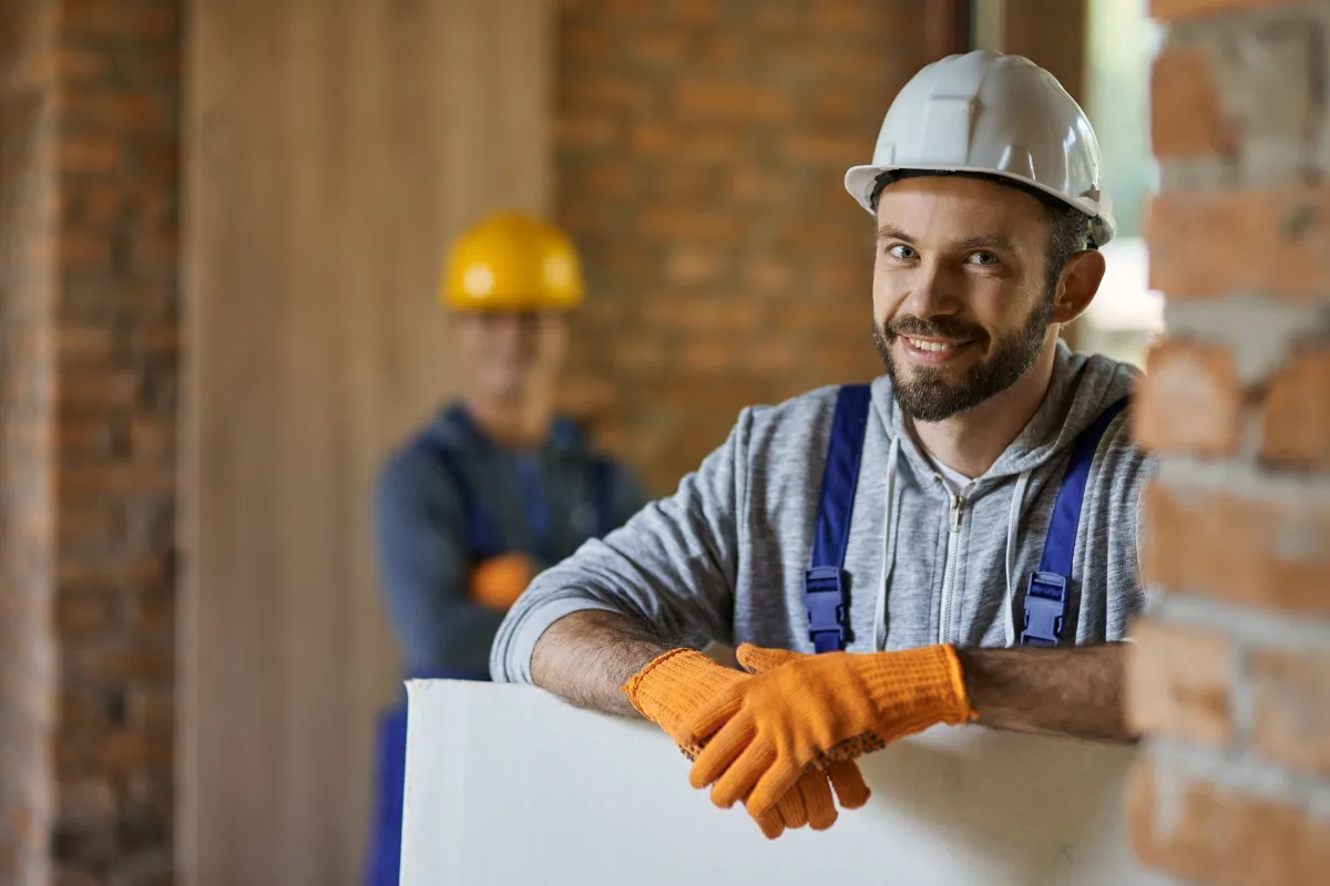 positive handsome young builder smiling
