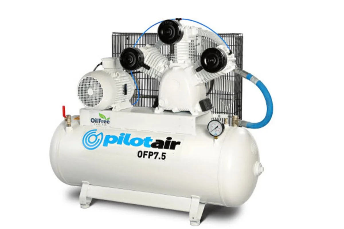Oil-free air compressor unit (PilotAir OFP7.5) with belt-driven pump, gauge, and blue hose on top of a horizontal tank